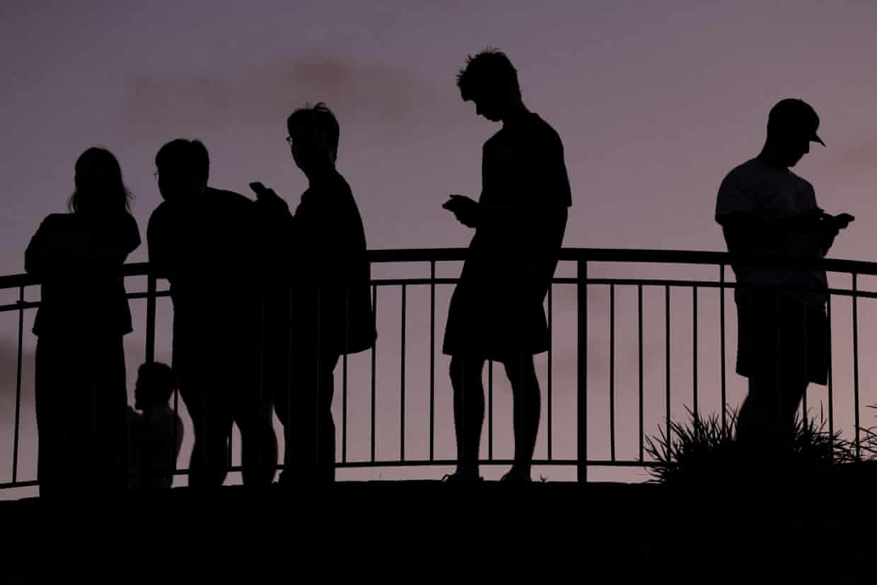 Kids on phones in silhouette