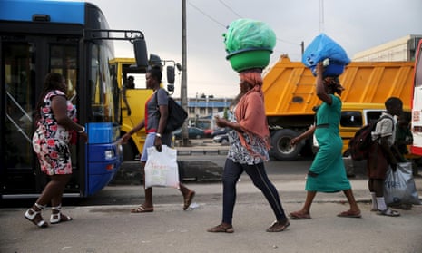 Women sell drinks along a road in Lagos.