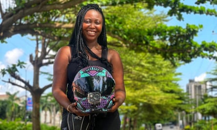 An African woman poses with a motorbike helmet