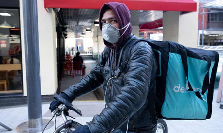 A Deliveroo rider wears a surgical face mask in Cardiff city centre