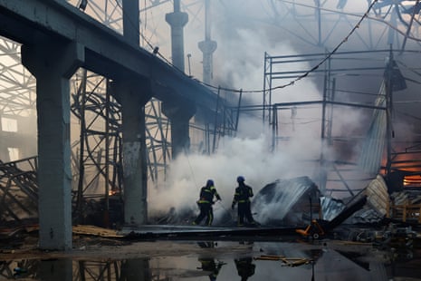 Los bomberos trabajan en el lugar de un almacén gravemente dañado durante un ataque con misiles rusos, en medio del ataque de Rusia a Ucrania, en Kiev.
