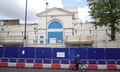 A man cycles past builders' hoardings at Pentonville prison