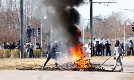 People burn branches to block a road before a demonstration in Norrköping on Sunday.