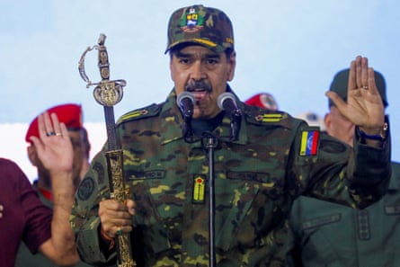 Maduro dressed in camouflage and holding a sword speaks at a rally