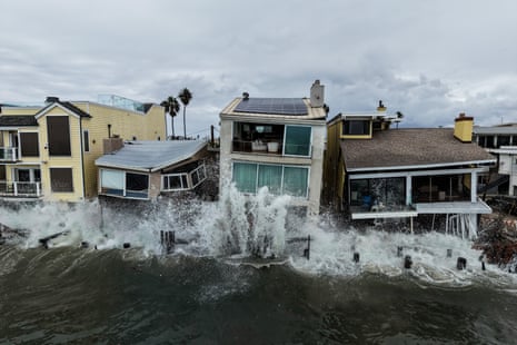 Storm waves crash over beachfront homes in Long Beach, California