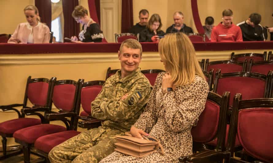 A man in military uniform enjoys an afternoon at the Kyiv Opera House.