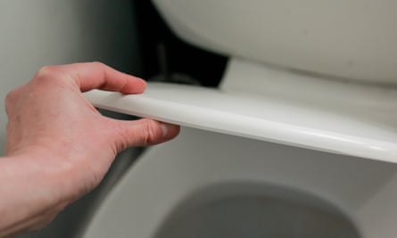 Hand holding a toilet lid