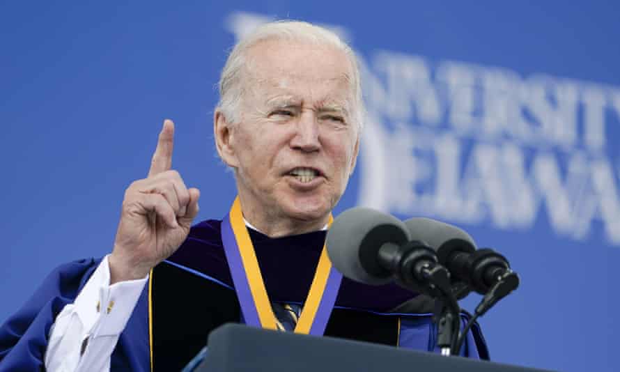 Biden holds up a finger while wearing graduation robes