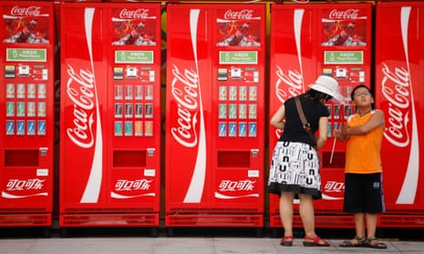 A  woman and boy next to Coca-Cola machines in Beijing