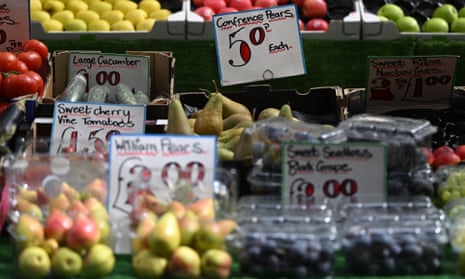 Fruit and vegetables displayed with prices on a trader's market stall