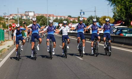 Israel-Premier Tech riders link arms during the final stage of the Vuelta on Sunday