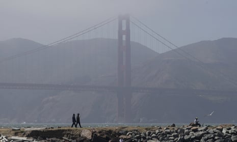 People walk on a path in front of the Golden Gate Bridge in San Francisco during the coronavirus outbreak.