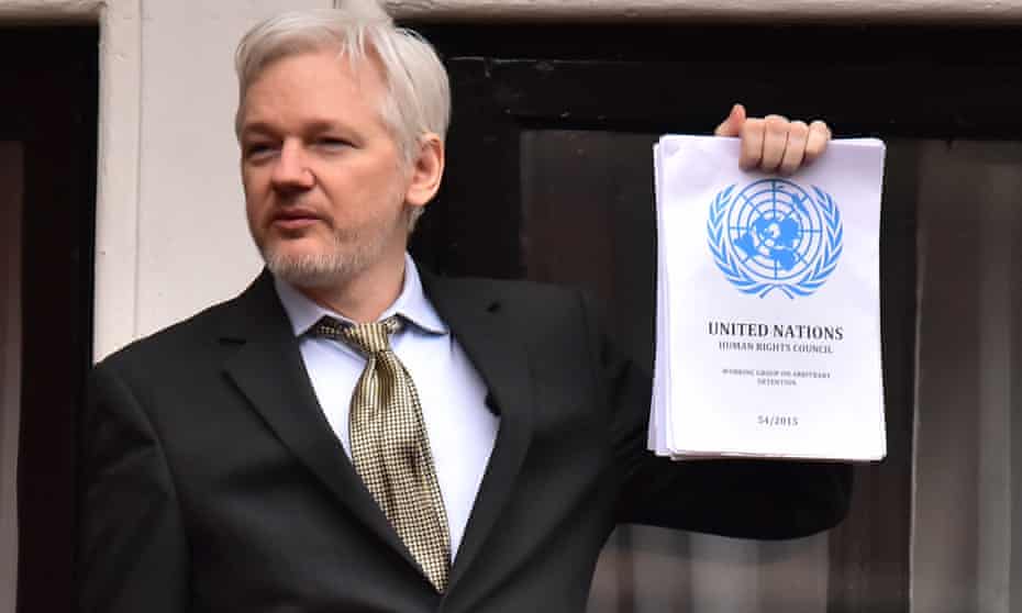 Julian Assange holds up copy of UN report into his detention