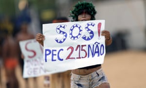 A indigenous woman protests at a sports arena during the first World Games for Indigenous Peoples in Palmas, Brazil, October 25, 2015. The sign says: “SOS! No to the proposed constitutional amendment 215 (PEC 215).” REUTERS/Ueslei Marcelino