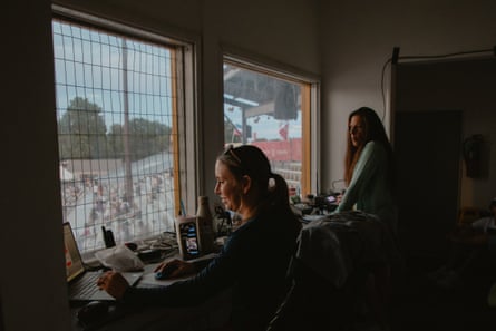Two women in a broadcast booth at a stadium
