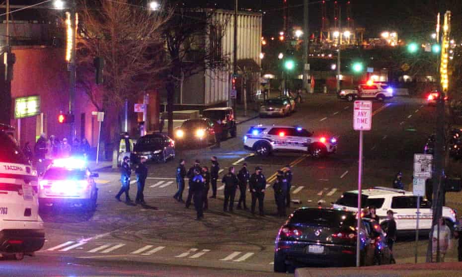 Tacoma police and other law enforcement officers stand in an intersection in downtown Tacoma, Washington.
