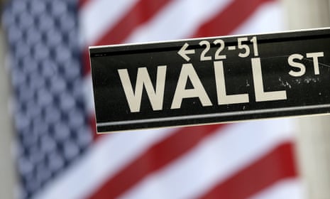 A Wall Street street sign is framed by an American flag
