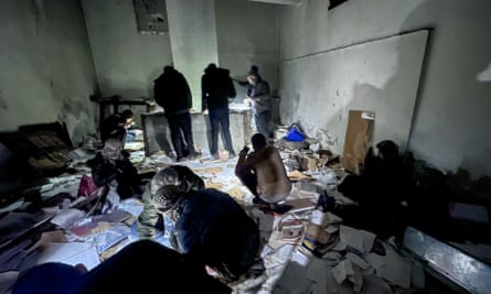 People looking through documents by torchlight