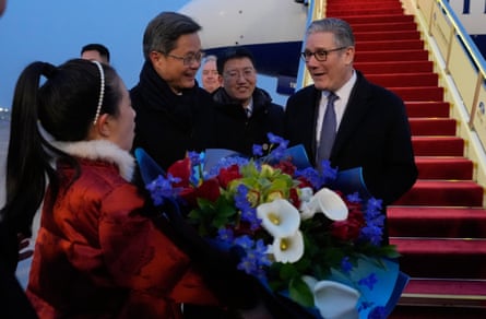 Lan Fo’an smiles as a girl hands a bouquet to Starmer as he steps on to the tarmac