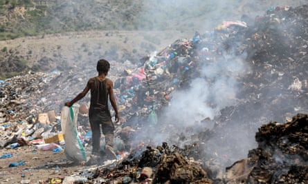 A young boy picks material from a rubbish dump in Taez, Yemen.