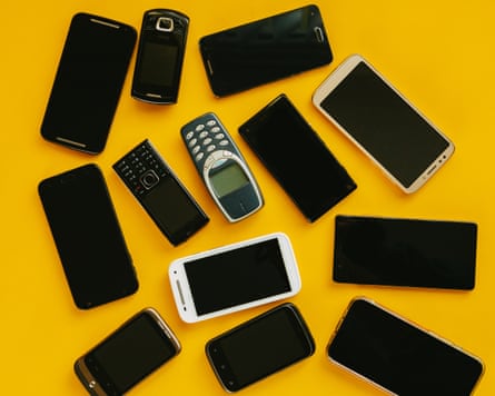 Different generations of mobile phone handsets on a yellow background.