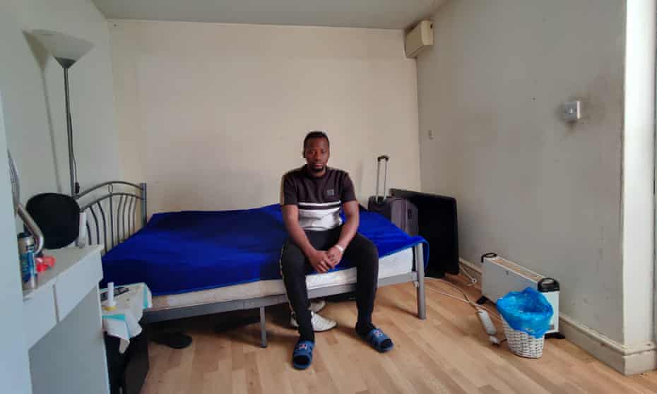 Hadie Touray in his room in a converted garage in Leyton, east London.