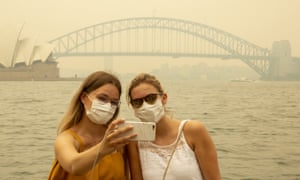 Khách du lịch người Đức Julia Wasmiller, trái, và Jessica Pryor chụp ảnh tự sướng đeo mặt nạ do khói thuốc lá dày đặc ở Sydney, ngày 19 tháng 12 năm 2019