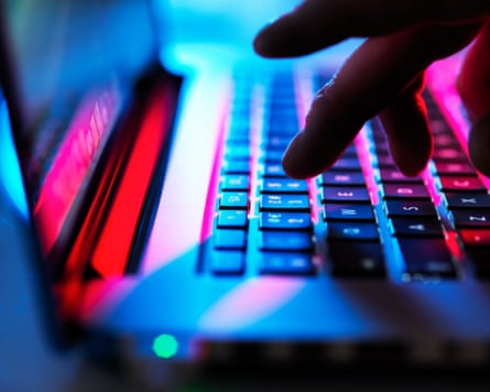 Man typing at his laptop computer at night