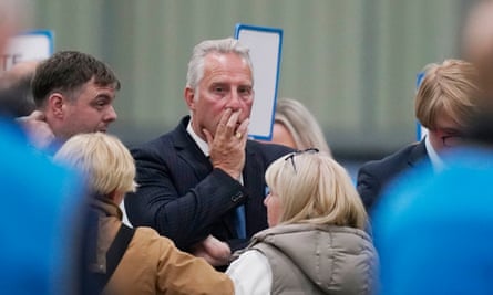 Ian Paisley stands with his left hand over his mouth