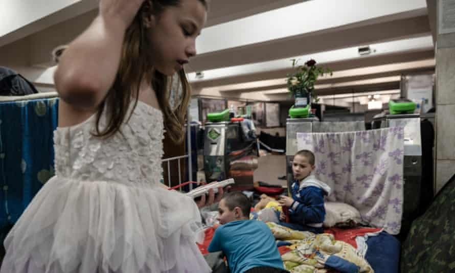 Victoria está usando um vestido de princesa enquanto comemora seu aniversário de 10 anos com outras pessoas abrigadas na estação de metrô.