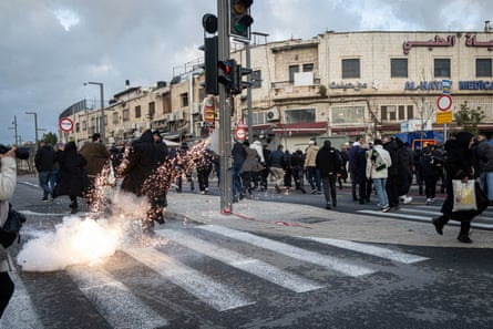 People walk away from a sparking, smoking grenade