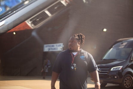 A man walks outside in a school parking lot