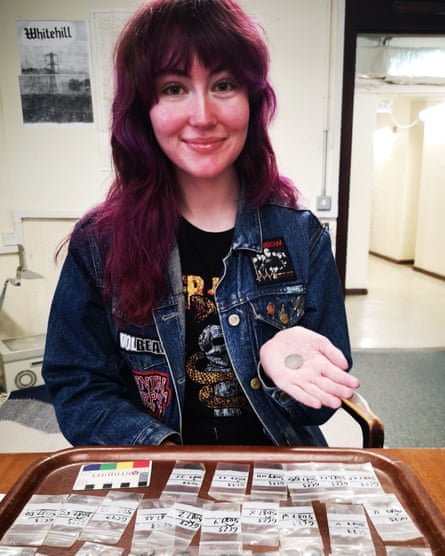 Люси Анкерс, студентка-археолог, держит одну из монет.