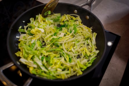 A huge frying pan with a mixed-leaf stir fry