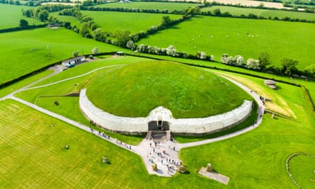 An aerial view of Newgrange surrounded by green fields.