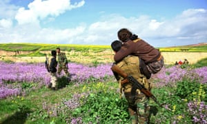 A Yazidi woman abducted by Isis is carried to safety near Mount Sinjar