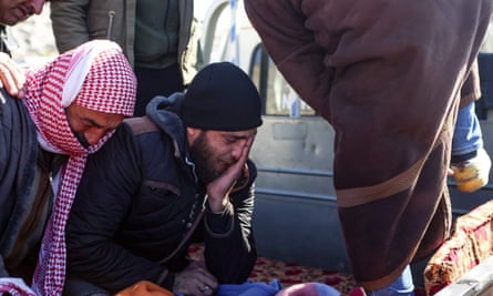 Men identify the body of a relative in Turkey’s Hatay region.