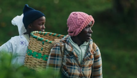 A woman with a basket on her back and a boy