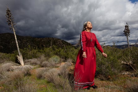 irginia Christman (Kumeyaay, Viejas Band of Kumeyaay Indians), 2023, in a red dress against a cloudy sky