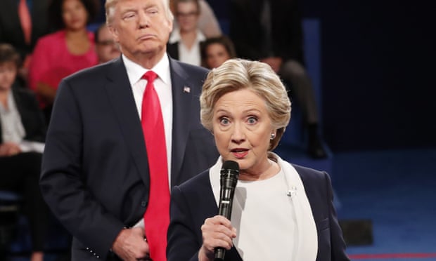 Donald Trump listens as Hillary Clinton answers a question from the audience at Washington University in St Louis in October 2016.