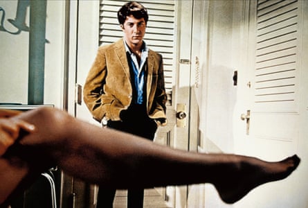 Anne Bancroft puts on a stocking as Dustin Hoffman looks on