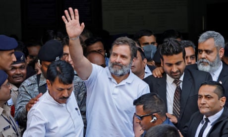 Rahul Gandhi waves as he leaves a court