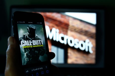 An image from Activision's Call of Duty is shown on a smartphone near a photograph of the Microsoft logo in this photo taken in New York, Thursday, June 15, 2023. A judge handed Microsoft a big victory on Tuesday, declining to stop its $69 billion takeover of video game maker Activision Blizzard.