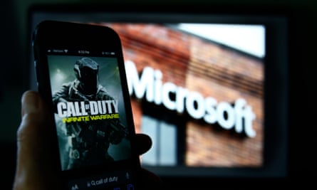 Call of Duty da Activision é mostrado em um smartphone perto de uma fotografia do logotipo da Microsoft nesta foto tirada em Nova York, quinta-feira, 15 de junho de 2023.