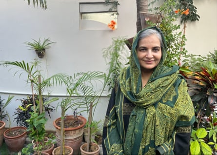 A smiling woman in a green sari