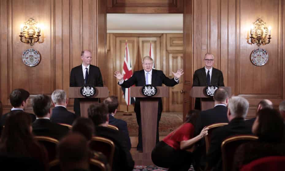Boris Johnson (C) speaks during a news conference while flanked by British chief medical officer Chris Whitty (L) and British lead science advisor Patrick Vallance (R) inside number 10 Downing Street