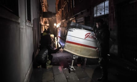 A stranded taxi boat is pictured in an alleyway after being washed away during an exceptional ‘alta acqua’