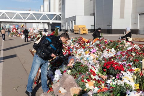 A man lays flowers to mourn victims of a terrorist attack near the Crocus city concert hall in Moscow, Russia, on Friday.
