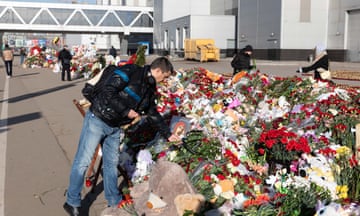 A man lays flowers to victims of the attack at Crocus city hall, Moscow, on 28 March.