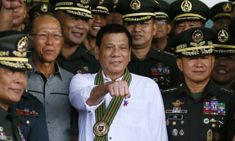 Rodrigo Duterte gestures as he poses with Philippine army officers during his visit to the army headquarters in Taguig, Philippines